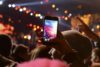 Konzertszenerie Frau filmt Bühne mit Smartphone